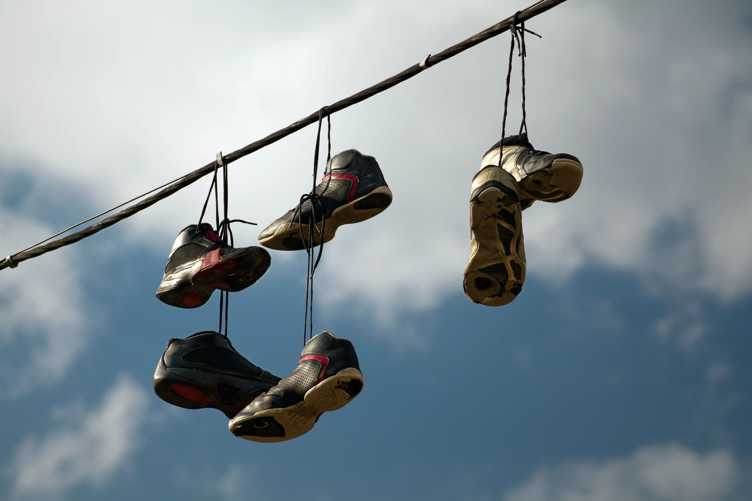 What Does it Really Mean When You See Shoes Hanging from a Telephone